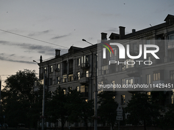 An apartment building is being seen at dusk as the city is switching off street lights due to power shortages in the region and to save elec...