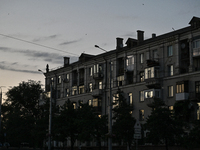 An apartment building is being seen at dusk as the city is switching off street lights due to power shortages in the region and to save elec...