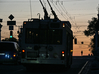 A trolleybus is being seen on the dark screen at night as the city is switching off street lights due to power shortages in the region and t...