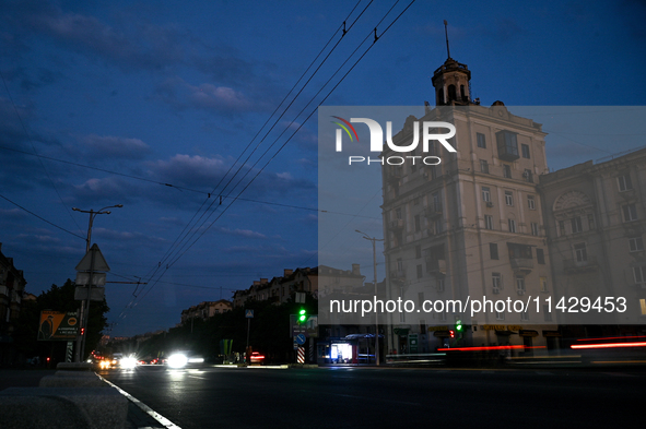 Cars are on the road at night as the city is switching off street lights due to power shortages in the region and to save electricity for re...