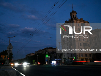 Cars are on the road at night as the city is switching off street lights due to power shortages in the region and to save electricity for re...