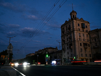 Cars are on the road at night as the city is switching off street lights due to power shortages in the region and to save electricity for re...