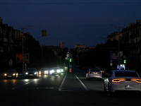 Cars are on the road at night as the city is switching off street lights due to power shortages in the region and to save electricity for re...