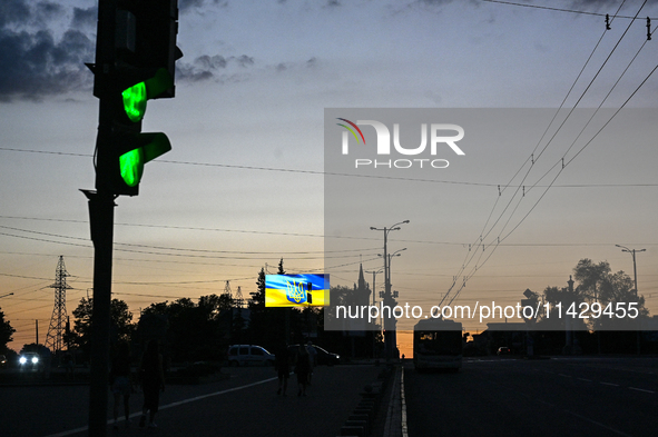 Traffic lights and a screen are being seen on the dark night as the city is switching off street lights due to power shortages in the region...