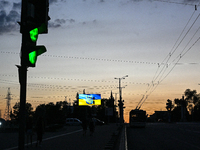 Traffic lights and a screen are being seen on the dark night as the city is switching off street lights due to power shortages in the region...