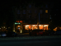 An illuminated restaurant is being seen at night as the city is switching off street lights due to power shortages in the region and to save...