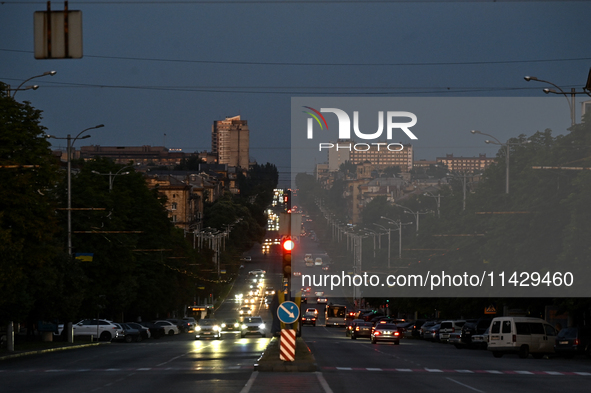 Cars are on the road at night as the city is switching off street lights due to power shortages in the region and to save electricity for re...