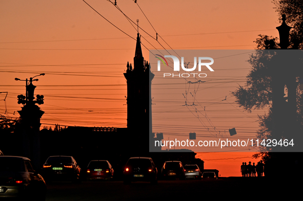 Cars are moving along a road at sunset as the city is switching off street lights due to power shortages in the region and to save electrici...