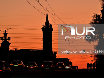 Cars are moving along a road at sunset as the city is switching off street lights due to power shortages in the region and to save electrici...