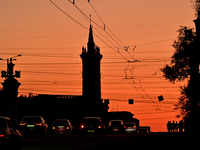 Cars are moving along a road at sunset as the city is switching off street lights due to power shortages in the region and to save electrici...