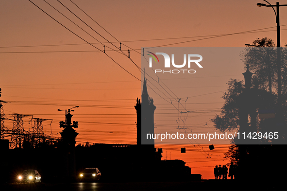 Cars are moving along a road at sunset as the city is switching off street lights due to power shortages in the region and to save electrici...