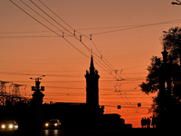 Cars are moving along a road at sunset as the city is switching off street lights due to power shortages in the region and to save electrici...