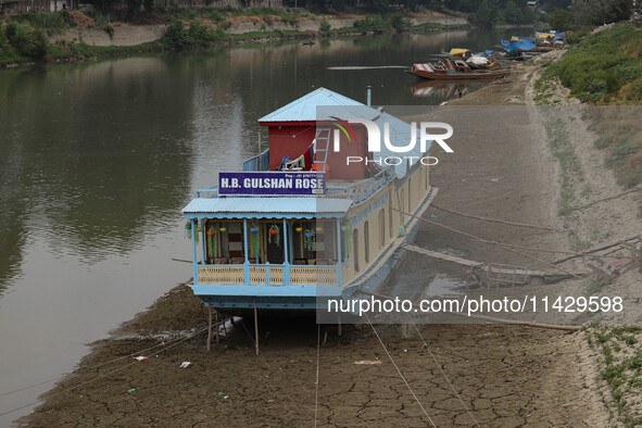 Owners are fixing wooden logs at the bottom to keep the balance of the houseboat on the dry beds of river Jhelum, as the dry spell is contin...