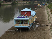 Owners are fixing wooden logs at the bottom to keep the balance of the houseboat on the dry beds of river Jhelum, as the dry spell is contin...