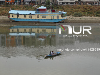 A man is fishing on the waters of river Jhelum as the dry spell is continuing in Srinagar, Jammu and Kashmir, on July 23, 2024. A prolonged...