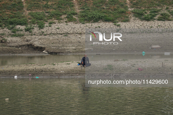 A man is fishing on the dried portion of the river Jhelum as the dry spell continues in Srinagar, Jammu and Kashmir, on July 23, 2024. A pro...