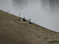 Men are fishing on the dried portion of the river Jhelum as the dry spell is continuing in Srinagar, Jammu and Kashmir, on July 23, 2024. A...