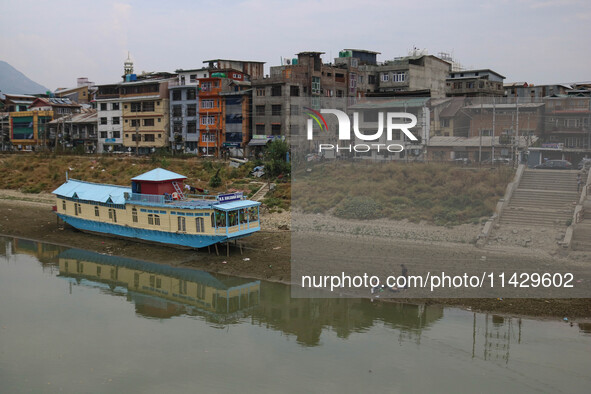 Men are fishing on the dried portion of the river Jhelum as the dry spell is continuing in Srinagar, Jammu and Kashmir, on July 23, 2024. A...