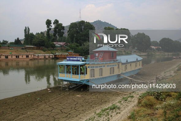 Owners are fixing wooden logs at the bottom to keep the balance of the houseboat on the dry beds of river Jhelum, as the dry spell is contin...