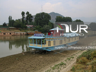 Owners are fixing wooden logs at the bottom to keep the balance of the houseboat on the dry beds of river Jhelum, as the dry spell is contin...