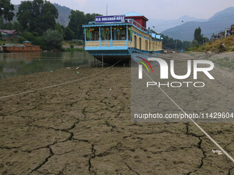 Owners are fixing wooden logs at the bottom to keep the balance of the houseboat on the dry beds of river Jhelum, as the dry spell is contin...