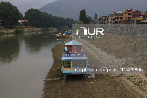 Owners are fixing wooden logs at the bottom to keep the balance of the houseboat on the dry beds of river Jhelum, as the dry spell is contin...