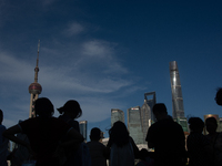 Tourists are staying in the shadow at the Bund in Shanghai, China, on July 23, 2024. (