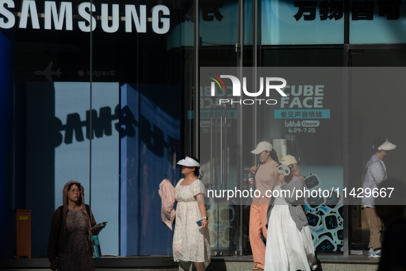 People are standing in front of a Samsung storefront on Nanjing Road in Shanghai, China, on July 23, 2024. 