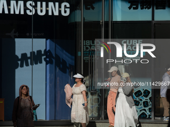 People are standing in front of a Samsung storefront on Nanjing Road in Shanghai, China, on July 23, 2024. (