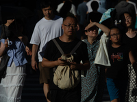 People are crossing the street on Nanjing Road in Shanghai, China, on July 23, 2024. (