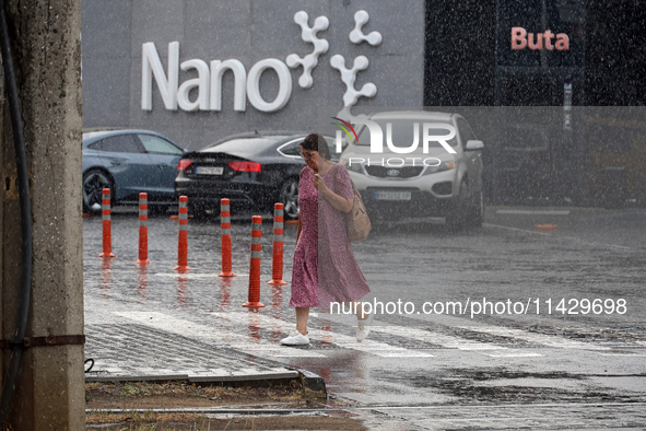 A woman is crossing a street in the rain in Odesa, Ukraine, on July 22, 2024. NO USE RUSSIA. NO USE BELARUS. 