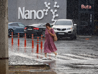 A woman is crossing a street in the rain in Odesa, Ukraine, on July 22, 2024. NO USE RUSSIA. NO USE BELARUS. (