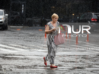 A woman is walking along a street in the rain in Odesa, Ukraine, on July 22, 2024. NO USE RUSSIA. NO USE BELARUS. (