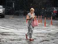 A woman is walking along a street in the rain in Odesa, Ukraine, on July 22, 2024. NO USE RUSSIA. NO USE BELARUS. (