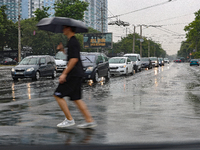 A man is crossing a street with an umbrella in the rain in Odesa, Ukraine, on July 22, 2024. NO USE RUSSIA. NO USE BELARUS. (