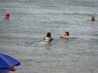 People are bathing in the Black Sea during the rain in Odesa, Ukraine, on July 22, 2024. (