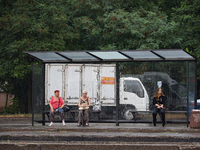 Women are staying at a public transport stop during the rain in Odesa, Ukraine, on July 22, 2024. NO USE RUSSIA. NO USE BELARUS. (