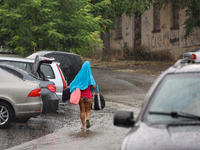 A woman is leaving a beach covered with a towel as it rains in Odesa, Ukraine, on July 22, 2024. NO USE RUSSIA. NO USE BELARUS. (