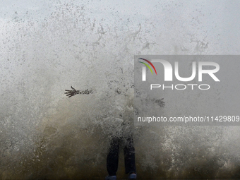 Visitors are reacting to sea waves at the Marine Drive promenade during high tide in Mumbai, India, on July 23, 2024. (