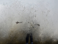 Visitors are reacting to sea waves at the Marine Drive promenade during high tide in Mumbai, India, on July 23, 2024. (