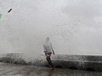 Visitors are reacting to sea waves at the Marine Drive promenade during high tide in Mumbai, India, on July 23, 2024. (