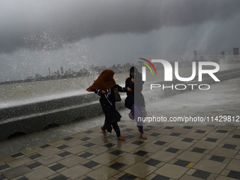 Visitors are reacting to sea waves at the Marine Drive promenade during high tide in Mumbai, India, on July 23, 2024. (