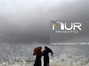 Visitors are reacting to sea waves at the Marine Drive promenade during high tide in Mumbai, India, on July 23, 2024. (