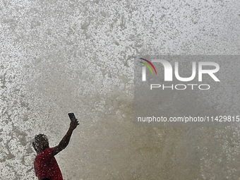 Visitors are reacting to sea waves at the Marine Drive promenade during high tide in Mumbai, India, on July 23, 2024. (