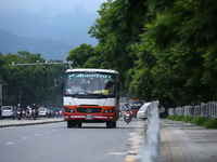 Vehicles are plying on the road of Lalitpur, Nepal, on July 23, 2024, against the backdrop of plants planted on the roadside that have turne...