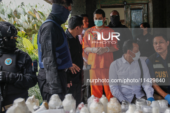 Indonesian National Narcotic Agency (BNN) officers are escorting the suspect after a raid of a drug lab, during a press conference in Gianya...