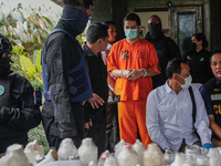 Indonesian National Narcotic Agency (BNN) officers are escorting the suspect after a raid of a drug lab, during a press conference in Gianya...