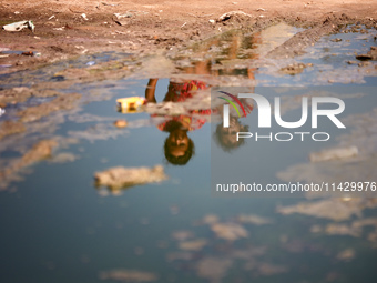 Palestinian children are sitting on a street flooded with sewage water in Deir el-Balah, in the central Gaza Strip, on July 23, 2024, as mun...