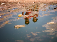 Palestinian children are sitting on a street flooded with sewage water in Deir el-Balah, in the central Gaza Strip, on July 23, 2024, as mun...