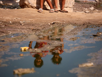 Palestinian children are sitting on a street flooded with sewage water in Deir el-Balah, in the central Gaza Strip, on July 23, 2024, as mun...